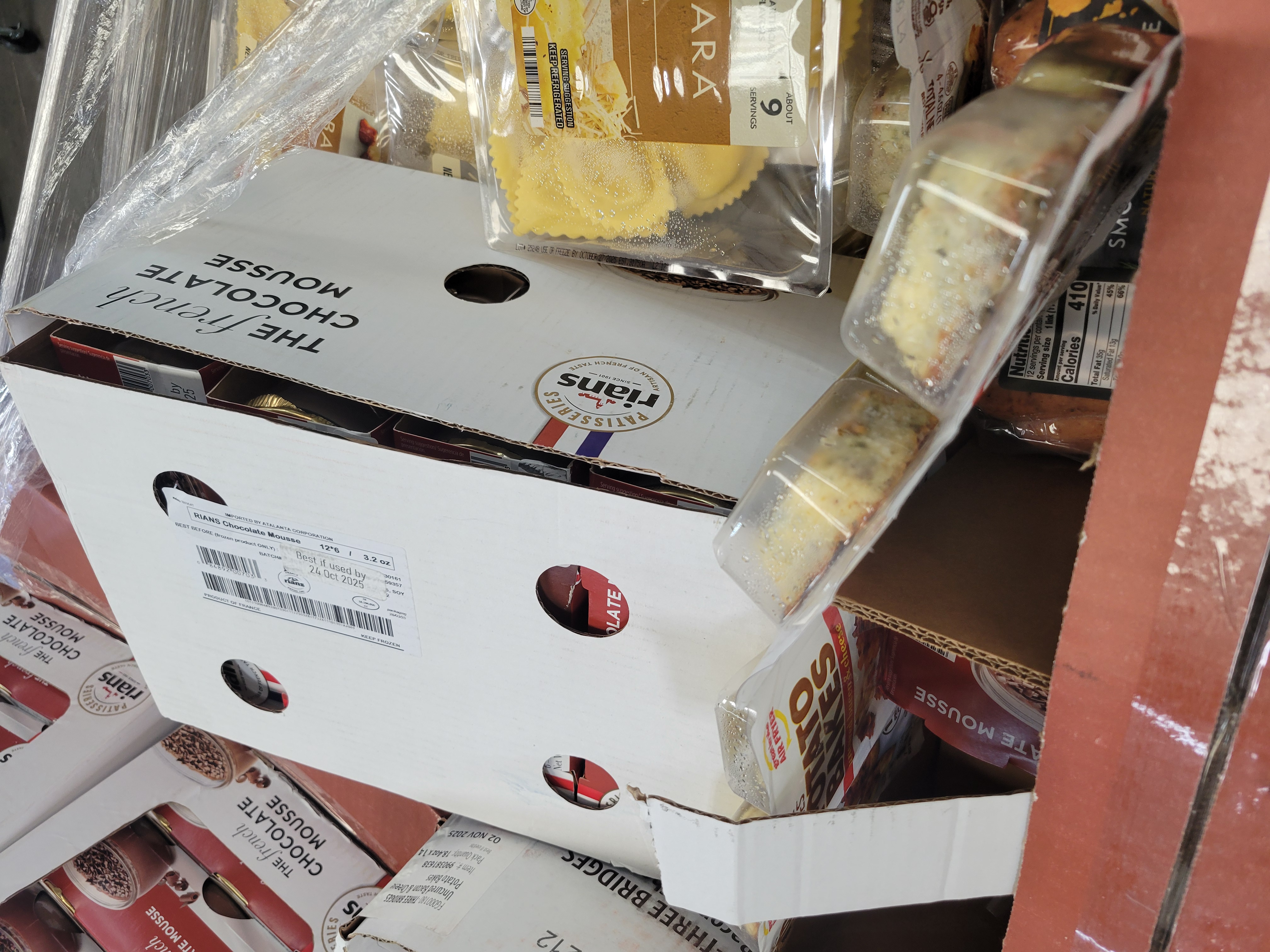 Boxes of chocolate mousse next to packages of pasta in a box.